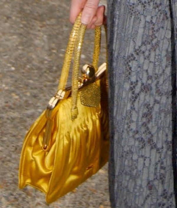 Captured at a fashion event, Bonnie Wright carries a vibrant Miu Miu pleated satin and Tejus frame bag in bright yellow
