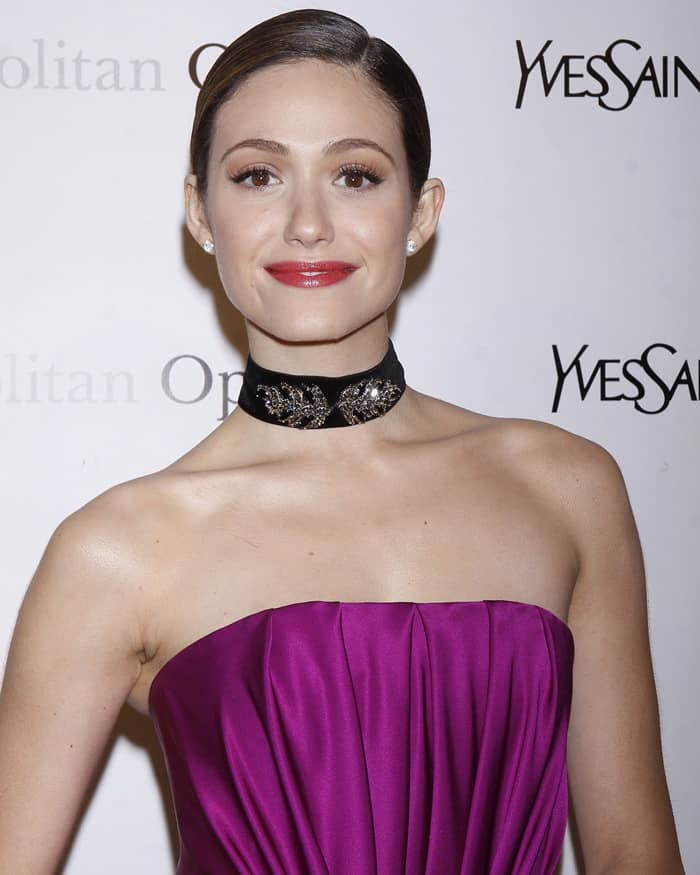 The choker, being an eye-catching accessory, harmonized well with the simplicity and bold color of Emmy Rossum's magenta satin dress, creating a balanced and glamorous look