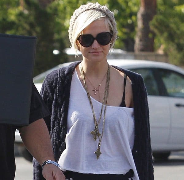 Ashlee Simpson showcases her unique style with a layered cross pendant necklace, adding a touch of elegance to her look
