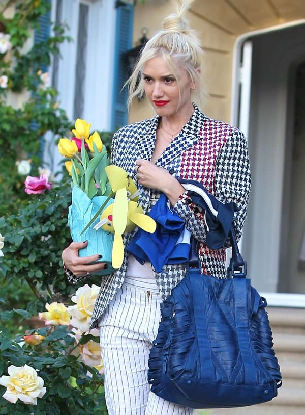 Gwen Stefani, the epitome of a trendy, doting mom, leaves with tulips and her son's jacket, wearing her own A.L.C. Gwen pants