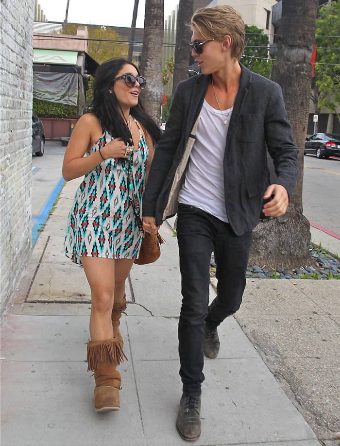 On April 11, 2012, Vanessa Hudgens was seen leaving Planet Blue with Austin Butler wearing Blu Moon The Exile dress in tribal print, Kettle Black Koolaburra tall fringe boots, and accessorized with a Spell Coyote Heishi bead necklace, Spell Pocahontas Princess necklace, Spell hand carved bull skull ring, and a Sabrina Tach shredded suede bucket bag