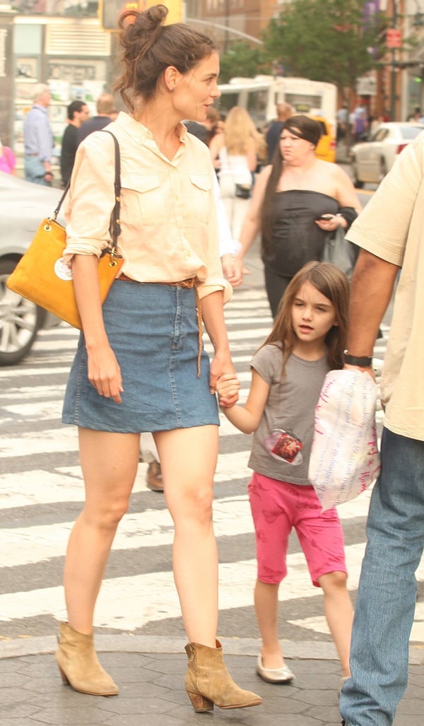 Katie Holmes nails effortless city chic in a denim mini skirt, rolled-up button-down, Isabel Marant Forbes suede ankle boots, and a mustard Steven Alan shoulder bag