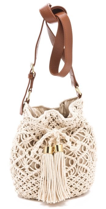 Creme crochet Tory Burch Claire bucket bag with gold-tone hardware, tan leather trim, and a single adjustable flat shoulder strap