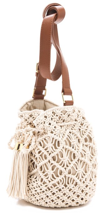 Creme crochet Tory Burch Claire bucket bag with gold-tone hardware, tan leather trim, and a single adjustable flat shoulder strap