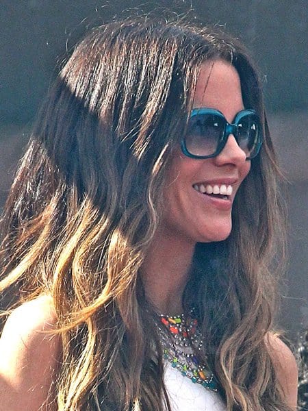 Kate Beckinsale enhances her summery outfit with a striking Tom Binns tiered multicolor necklace, adding a splash of color to her all-white ensemble