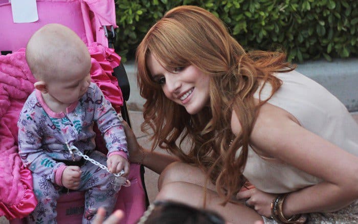 Bella Thorne posing with a baby at the 2012 Teen Choice Awards