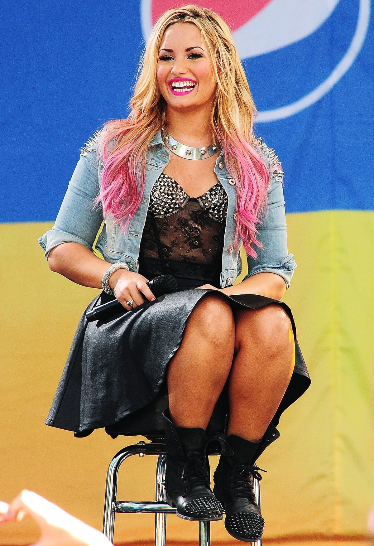 Demi Lovato wears a studded floral lace bustier with a black leather skirt and a denim cropped jacket