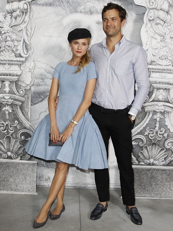 Diane Kruger, posing with Joshua Jackson, elegantly showcased a Chanel Resort 2013 short-sleeve denim dress, complemented by a Chanel Spring 2012 ear cuff, Jaeger-Lecoultre Grande Reverso watch, Chanel metallized python clutch, and Christian Louboutin Pigalle spiked flats at the Chanel Haute-Couture Show during Paris Fashion Week Fall 2012 on July 3, 2012