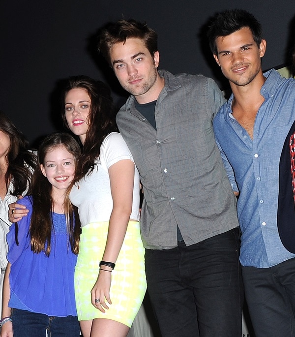Kristen Stewart wears her hair down as she poses with Mackenzie Foy, Robert Pattinson, and Taylor Lautner at the panel for "The Twilight Saga: Breaking Dawn Part 2"