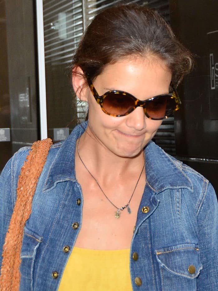 Katie Holmes keeps it casual in a yellow top layered with her favorite Current/Elliott 'The Snap' denim jacket and tortoiseshell sunglasses