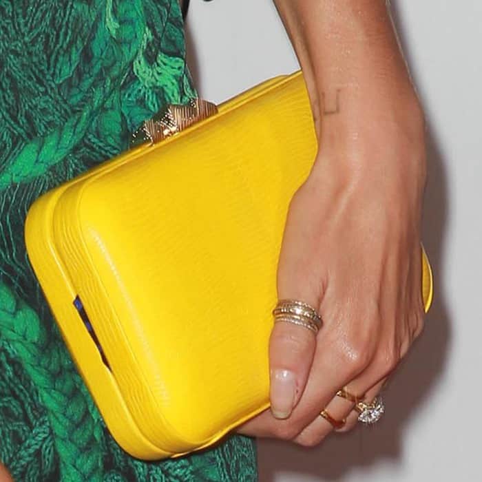 Nikki carries a yellow Rebecca Minkoff lizard-embossed clutch