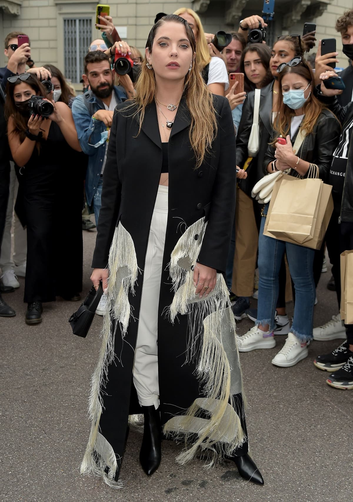Ashley Benson in a fringe coat and black Chelsea boots during the Salvatore Ferragamo fashion show