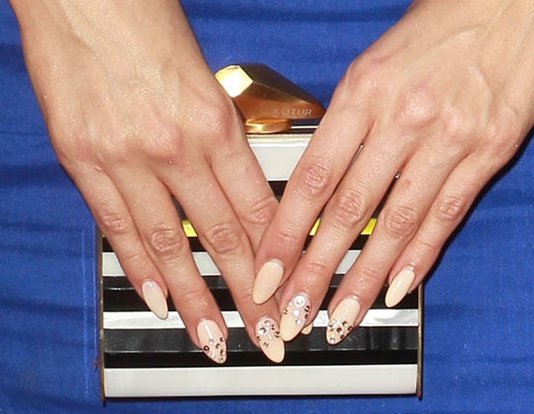 Debby Ryan showcased her nude embellished nails while holding a chic striped Kotur box minaudière, perfectly complementing her bold blue ensemble