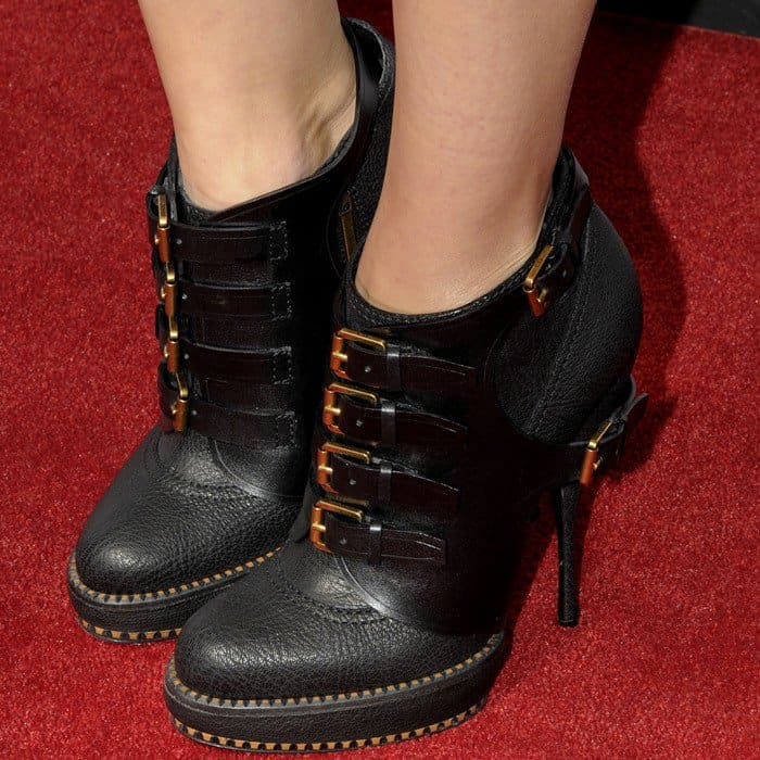Marion Cotillard's black leather ankle boots feature five bold gold buckles running across the front, adding an edgy, military-inspired vibe