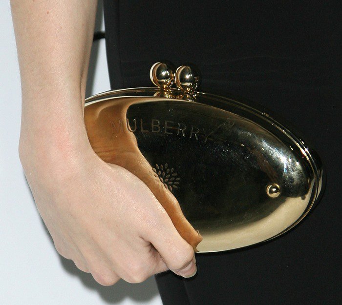 Anna Kendrick adds a touch of glamour to her ensemble with a sleek gold Mulberry clutch