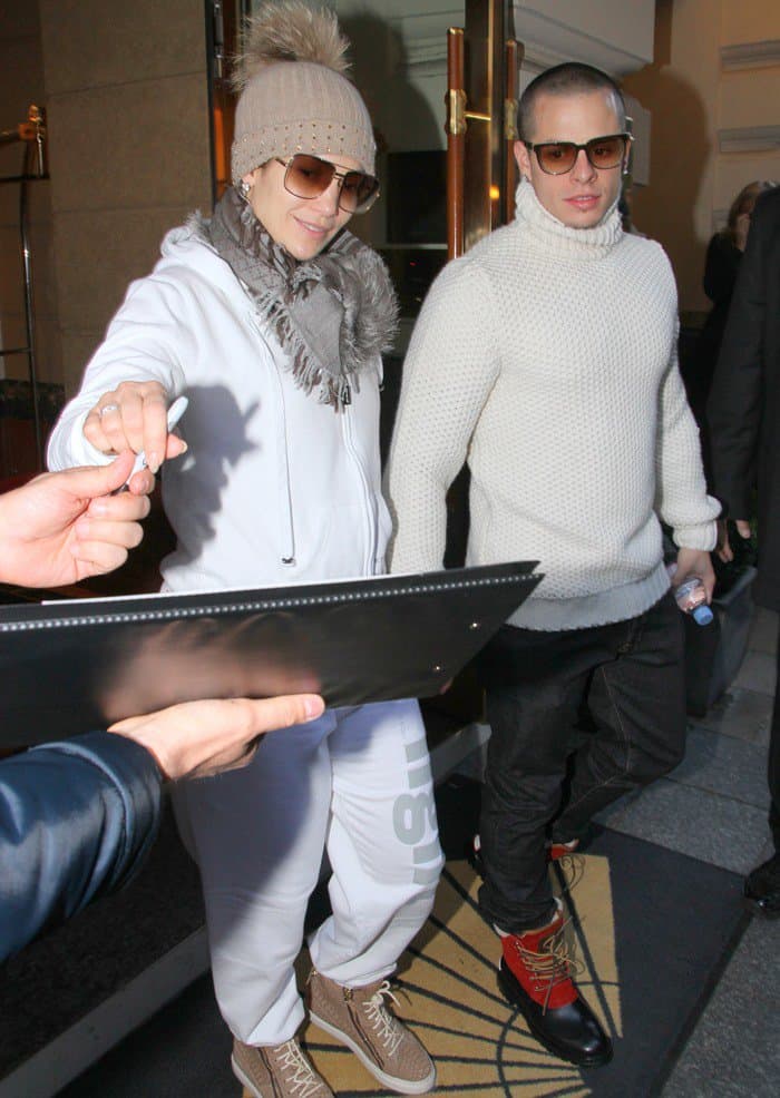 Post-concert glow: Jennifer Lopez signs autographs for fans, looking radiant in a crisp white tracksuit on October 25, 2012, in Munich