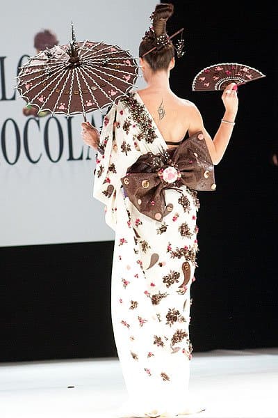 Natasha St-Pier elegantly showcases a chocolate-crafted kimono, complete with a chocolate parasol, fan, and obi bow, blending tradition with confectionery art
