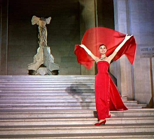 Jo Stockton (Audrey Hepburn) glides down the Daru steps, holding a red scarf above her head in the film Funny Face