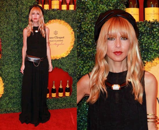 Rachel Zoe's choice of a chic black ensemble, complemented by statement accessories like a bold collar necklace and an arm cuff, showcases her signature boho-glam aesthetic