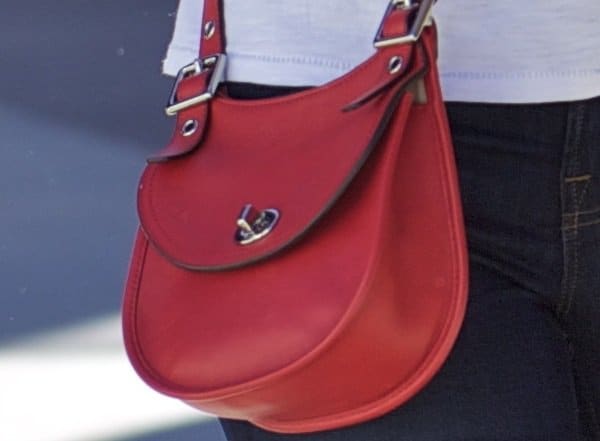 The Legacy leather mini saddle in Carnelian from Coach adorns Elizabeth Banks' shoulder, proving that practicality and style can go hand-in-hand, even during a casual family outing