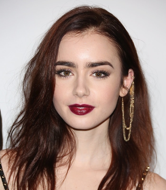 Lily Collins showcases her unique gothic glam look and a leaf-adorned ear cuff chain that stands out as a bold fashion statement