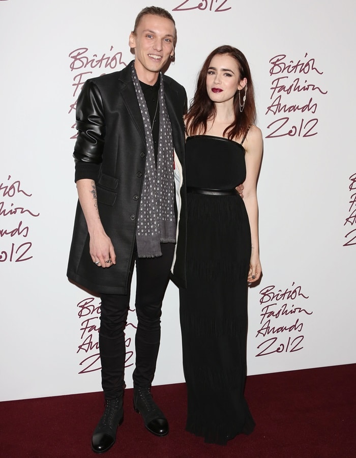 Lily Collins exudes gothic glam in a strapless black Mulberry gown with pointed heels, while Jamie Campbell Bower opts for edgy elegance in a leather coat and lace-up boots at the British Fashion Awards held at The Savoy in London on November 27, 2012