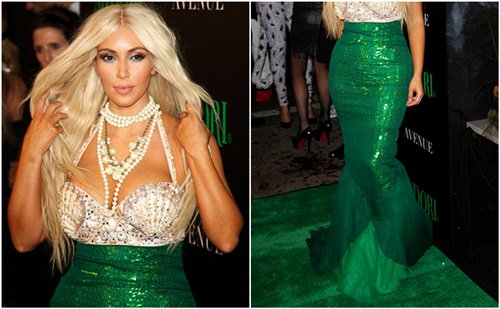 Kim Kardashian wears a blonde wig with a shell-encrusted top and a green fishtail dress