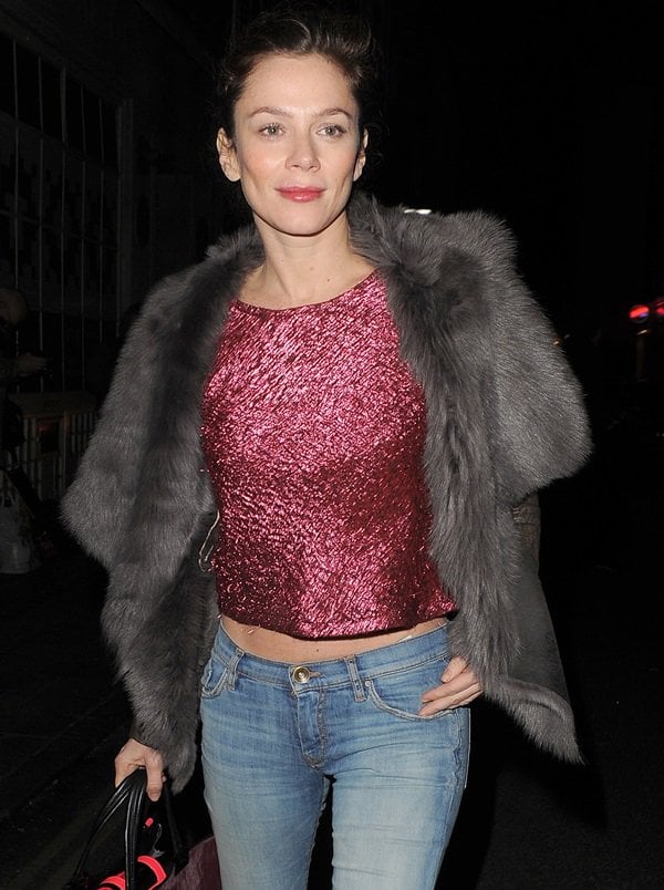 The luminous metallic pink top Anna Friel dons gracefully softens the bold, edgy statement of her leather and shearling jacket, showcasing her impeccable sense of balance in fashion