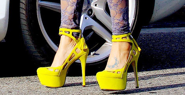 Bai Ling highlights her foot tattoo in bold yellow Michael Antonio “Lavonne” platform heels, featuring edgy cutout details and a sky-high silhouette