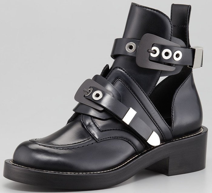 Finished with bound piping for a more refined finish, this black calfskin Balenciaga ankle boot stands out in a crowd with statement hardware and edgy cutouts