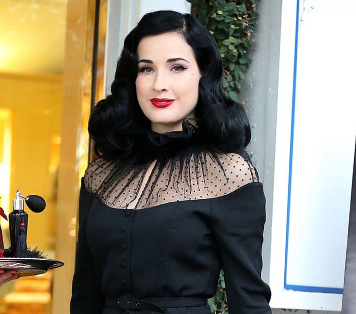 Dita Von Teese wears soft curls in her dark hair to a pre-Christmas promotional event for Dita's new perfume