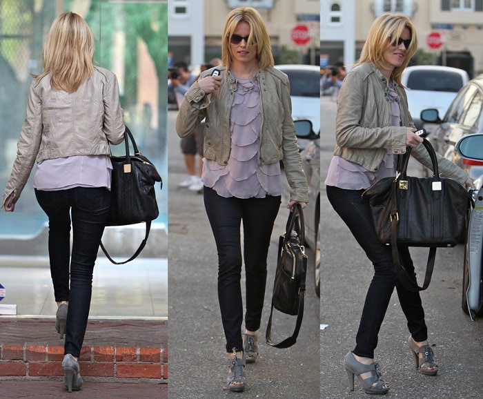Elizabeth Banks effortlessly combines edgy and feminine styles in a layered ruffled blouse, leather jacket, and sleek grey heels