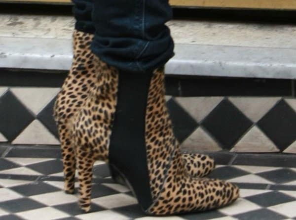 Geri Halliwell makes a bold statement with her feet, showcasing fierce leopard print booties that perfectly complement her eclectic and stylish ensemble