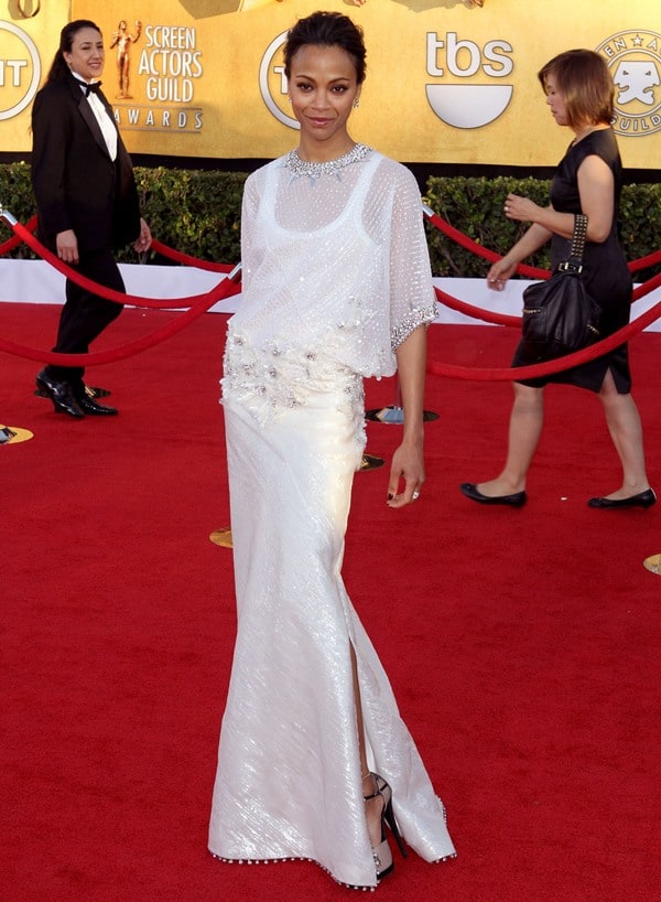 Zoe Saldana poses on the red carpet in a floor-length white Givenchy Couture gown