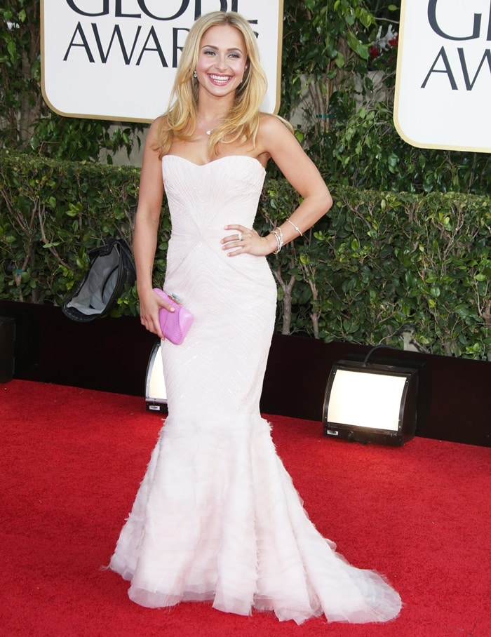 Hayden Panettiere, a Golden Globe nominee, elegantly dressed in a white Roberto Cavalli gown, complemented by a pink minaudière