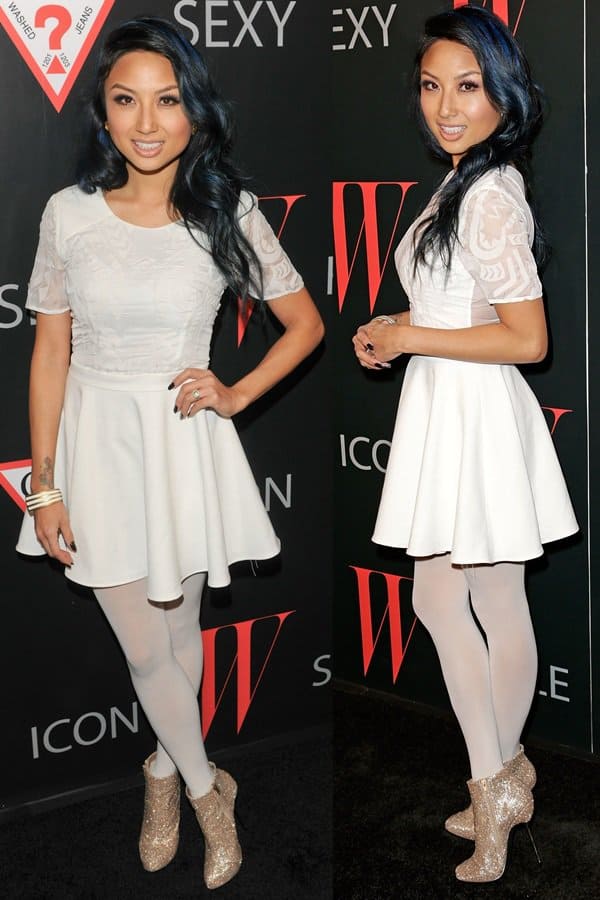 Jeannie Mai flaunts her legs in a short white dress and matching opaque tights
