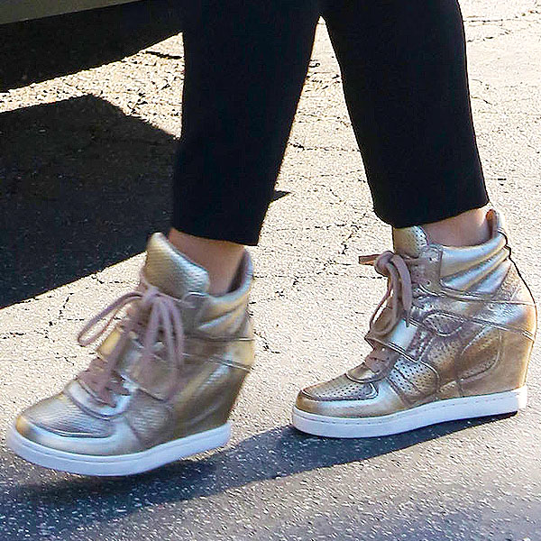 Jenna Dewan-Tatum's metallic gold wedge sneakers add a trendy, elevated touch to her casual maternity outfit, combining both comfort and style for a chic, everyday look