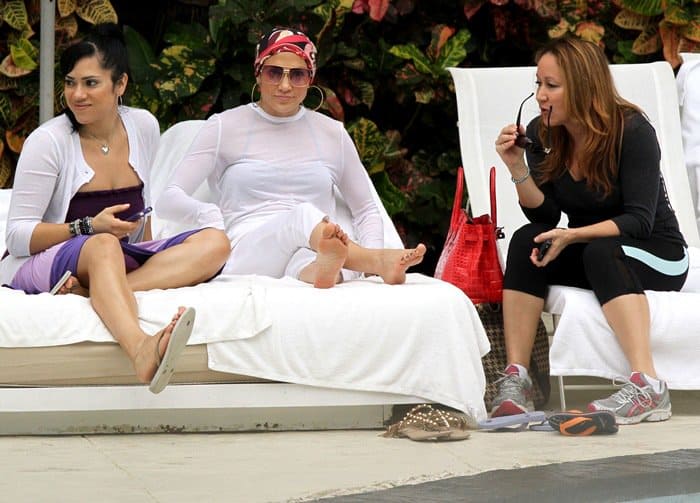 Barefoot Jennifer Lopez with colorful headscarf after taking off her Valentino Rockstud sandals