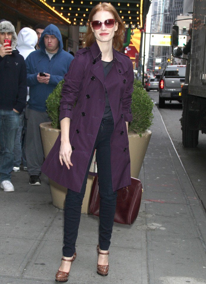 Jessica Chastain pairs a purple trench coat with navy skinny pants outside the Walter Kerr Theatre