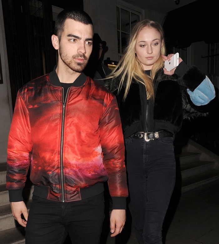 Wearing a red bomber jacket, Joe Jonas leaves a restaurant with Sophie Turner