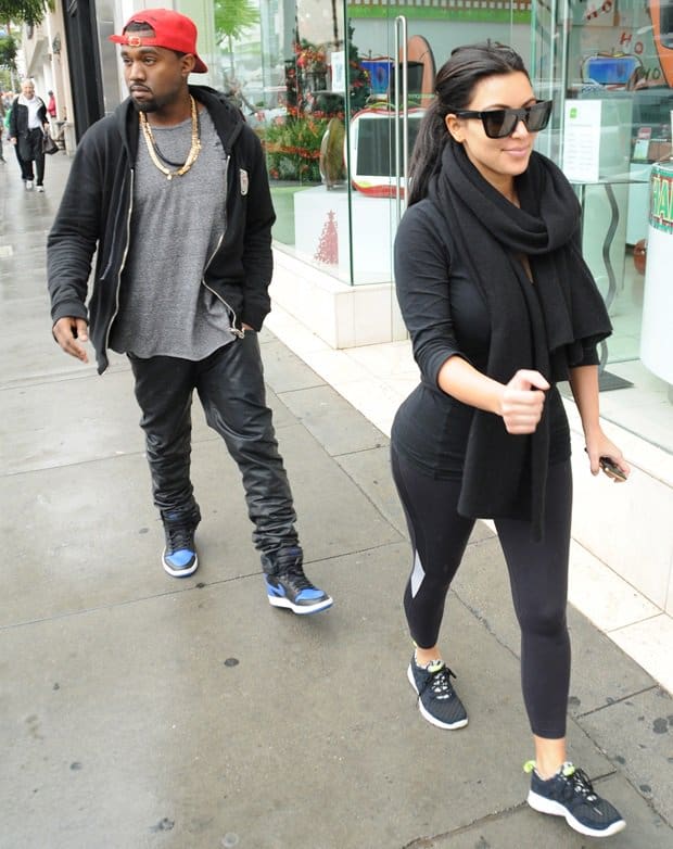 Kim Kardashian kept it sleek in all-black activewear, pairing her look with a cozy Degaine scarf and stylish black-and-yellow Nike Free sneakers, while Kanye West complemented her sporty vibe in Air Jordan 1 Retro sneakers