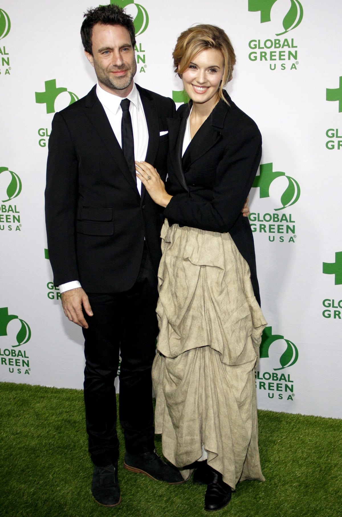 Matthew Cooke towers over Maggie Grace, who pairs a dramatic draped beige skirt with a structured black blazer and heeled boots at Global Green USA’s 12th Annual Pre-Oscar Party, held at Avalon Hollywood on February 18, 2015