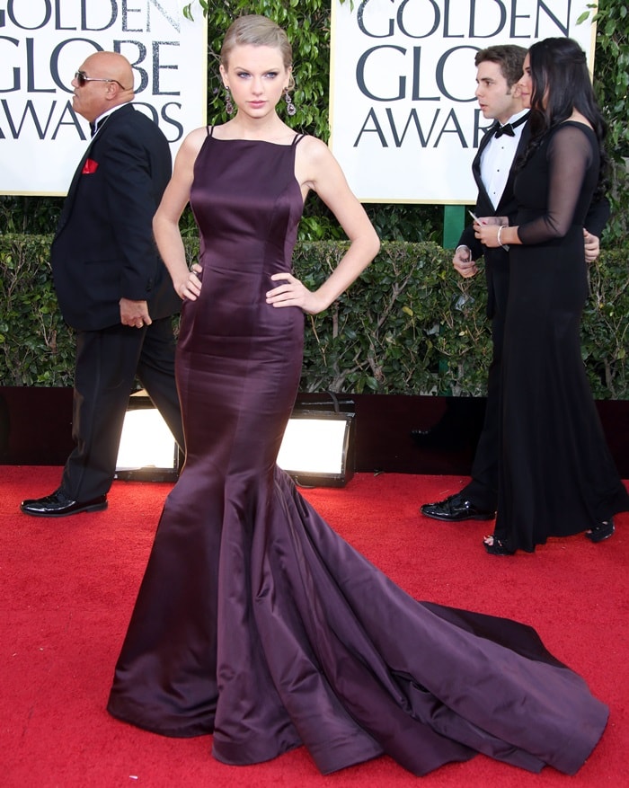 Taylor Swift exudes elegance on the Beverly Hilton Hotel's red carpet in a figure-hugging burgundy Donna Karan Atelier mermaid gown featuring a dramatic train and minimalist straps at the 70th Golden Globe Awards on January 13, 2013