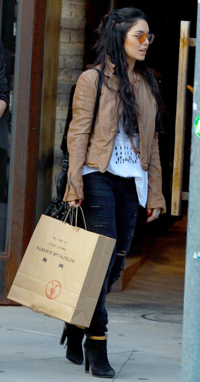 Vanessa Hudgens sported a buttery brown leather jacket paired with a loose white top, ripped skinny jeans, and complemented her look with stunning gold-trimmed pointy-toe ankle booties