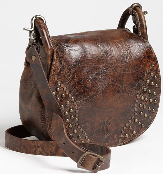 A saddle silhouette lends classic Western swagger to a studded leather crossbody with a burnished patina