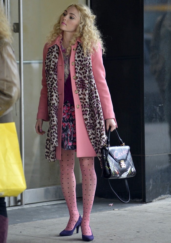 A glimpse into Carrie Bradshaw's fashion diary: AnnaSophia Robb dazzles in an iconic pink coat, capturing the essence of her character's unique style on the streets of New York City