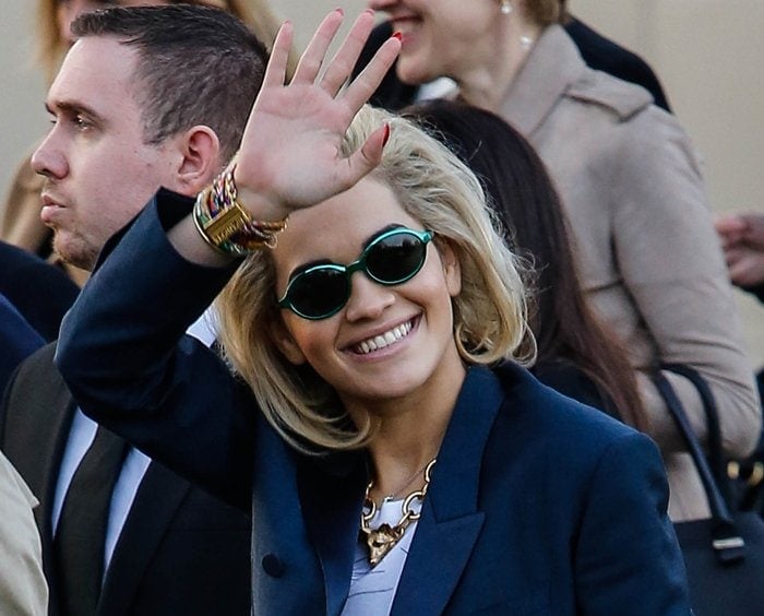 Rita Ora waves to fans and paparazzi at the Burberry fashion show