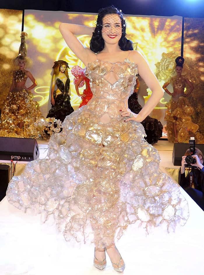 In a fusion of fashion and confection, Dita Von Teese dazzles in a bespoke dress constructed from chocolate biscuit tins, showcasing sustainable glamour at its finest