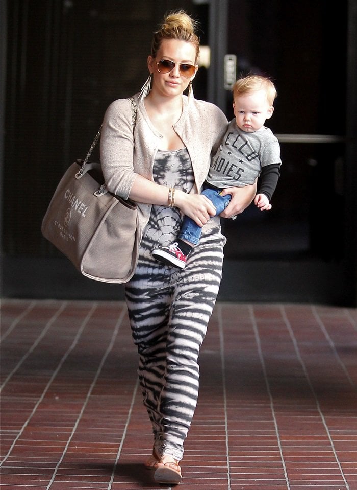 Hilary Duff was spotted arriving at Babies First Class styled in a bohemian-chic ensemble featuring a Raquel Allegra maxi tank tie-dye dress, Ray-Ban aviator sunglasses in gold-brown, a Chanel Cabas Ete 2012 bag, and K. Jacques Delta wrap sandals