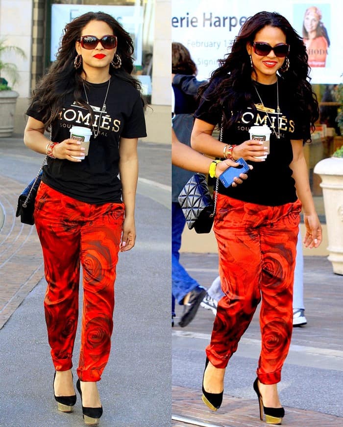 Christina Milian radiates style in a casual black tee and vibrant red floral pants by Alice + Olivia, shopping at The Grove in Los Angeles